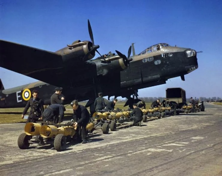 Royal Air Force armourers check over the sixteen 250lb bombs before they are loaded into a Short Stirling bomber