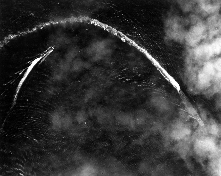 The Japanese aircraft carrier Akagi and a destroyer (probably Nowaki) maneuvering below thin clouds while under high-level bombing attack by U.S. Army Air Forces Boeing B-17E Flying Fortress bombers, shortly after 0800 hrs, 4 June 1942. No aircraft are visible on her flight deck and her forward elevator is in the down position. Akagi launched fighters at 0808 hrs and 0832 hrs. The photo was probably shortly taken after the 0808 hrs launch.