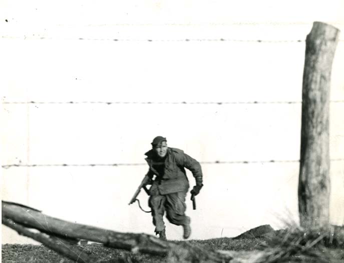 “We (Co/I-H ) were ordered into the attack from the north. It was hand-to-hand in fierce fighting. This is where the picture of me running toward a machine gun nest with a Tommy gun was taken”