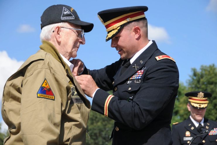 Army Maj. Peter Semanoff pins a Bronze Star medal onto the lapel of World War II veteran Clarence Smoyer, Sept. 18, 2019, at the National World War II Memorial in Washington.