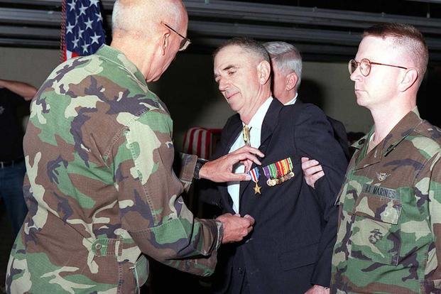 Lieutenant General P. K. Van Riper, Commanding General Marine Corps Combat Development Command, congratulates Gunnery Sgt. Carlos Hathcock (Ret.) after presenting him the Silver Star during a ceremony at the Weapons Training Battalion. Standing next to Gunnery Sgt. Hathcock is his son, Staff Sgt. Carlos Hathcock, Jr. (U.S. Marine Corps)