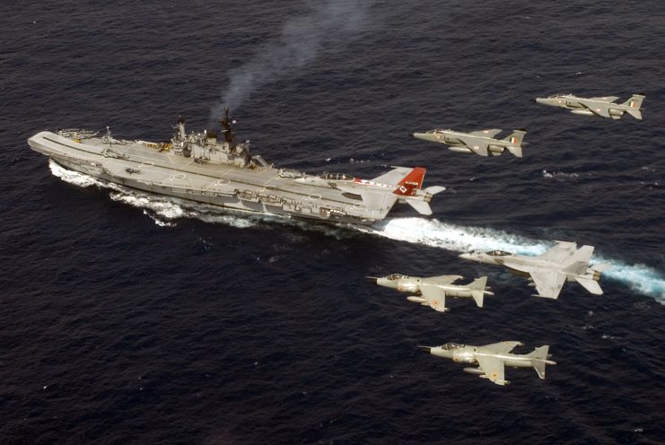 Indian Navy Sea Harriers and Indian Air Force SEPECAT Jaguars with US Navy F/A-18 Super Hornets flying over INS Viraat