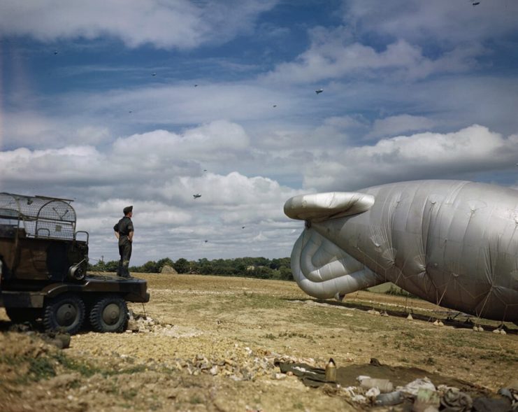 A barrage balloon of Balloon Command attached to a winching lorry and anchored to the ground near Biggin Hill, Kent. In the background a number of airborne balloons are visible. Large numbers of barrage balloons were located across the south-eastern approaches to London to combat the growing threat from V-1 flying bombs launched from Pas de Calais starting in June 1944.