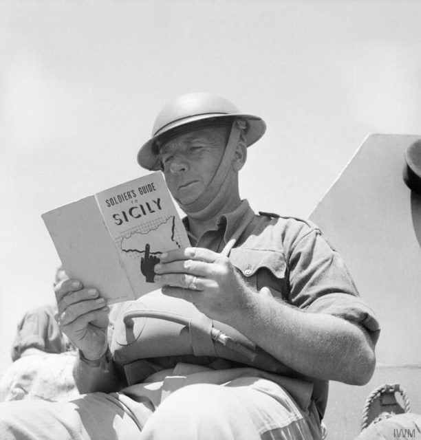 A British soldier reads up on Sicily, the target for the next Allied invasion, July 1943. [© IWM (NA 4105)]