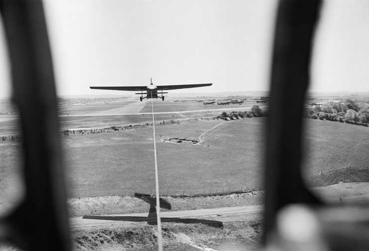 A GAL Hamilcar heavy glider clears to the airfield to the north after being towed off Runway 19 at Tarrant Rushton, Dorset, by a Handley Page Halifax target tug of No. 644 Squadron RAF.