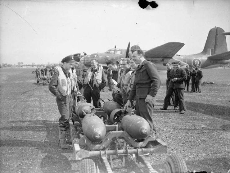 Aircrews of No 88 Squadron RAF standing around a bomb-trolley before they are loaded into the Squadron’s Douglas Boston Mark IIIs for a daylight sortie, at Attlebridge, Norfolk.