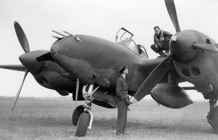 An RAF airman talks to a pilot of the 14th Fighter Group on the wing of his P-38 Lightning at Atcham, England.