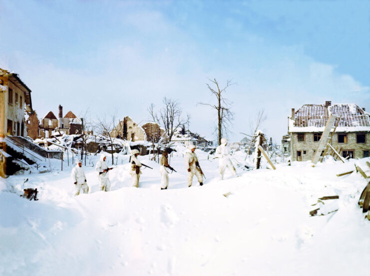 Members of the 7th Armored Division walking through the ruins of St. Vith, Belgium