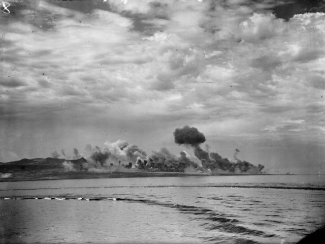 Bombs bursting on the docks and harbour of Pantelleria, as seen from on board the cruiser HMS ORION, in preparation for the allied invasion of the island. Pantelleria, Sicily, 1943. [© IWM (A 17666)]