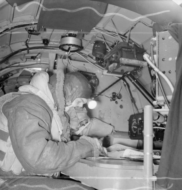 Flying Officer P Ingleby, the navigator of an Avro Lancaster B Mark III of No. 619 Squadron RAF based at Coningsby, Lincolnshire, seated at his table in the aircraft.