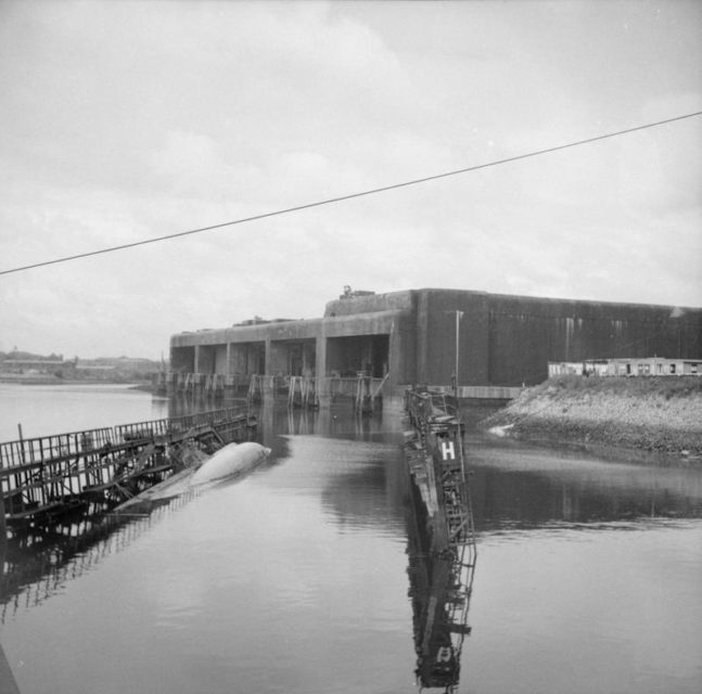 German U-Boat pens at Hamburg with a scuttled U-Boat in the foreground.