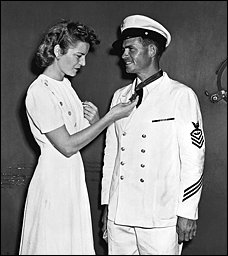 Alice Finn admiring the Medal of Honor around John Finn's neck