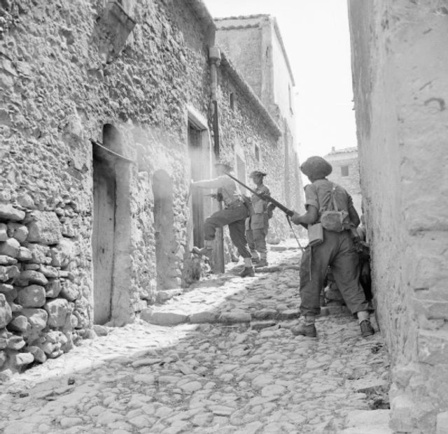 Men of the 6th Inniskillings, 38th Irish Brigade, searching houses during mopping up operations in Centuripe, Sicily. August 1943. [© IWM (NA 5388)]