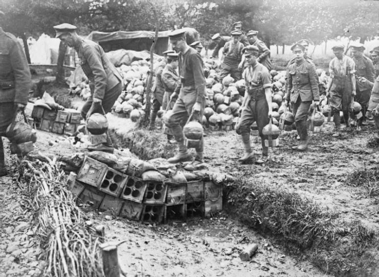Photograph of British troops carrying 2 inch mortar bombs (‘Toffee Apples’) by hand, Acheux, Somme, France.