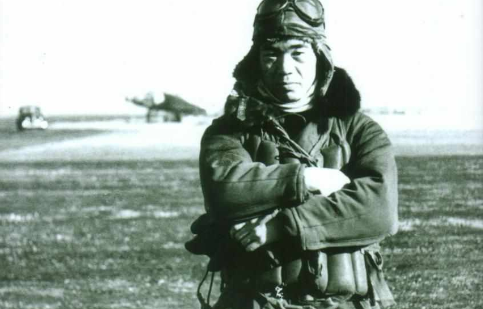 Saburō Sakai standing with his arms crossed