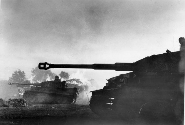 South of Orel, Panzer Mk VI Tiger tanks attack, in the background a building burns – By Bundesarchiv – CC BY-SA 3.0