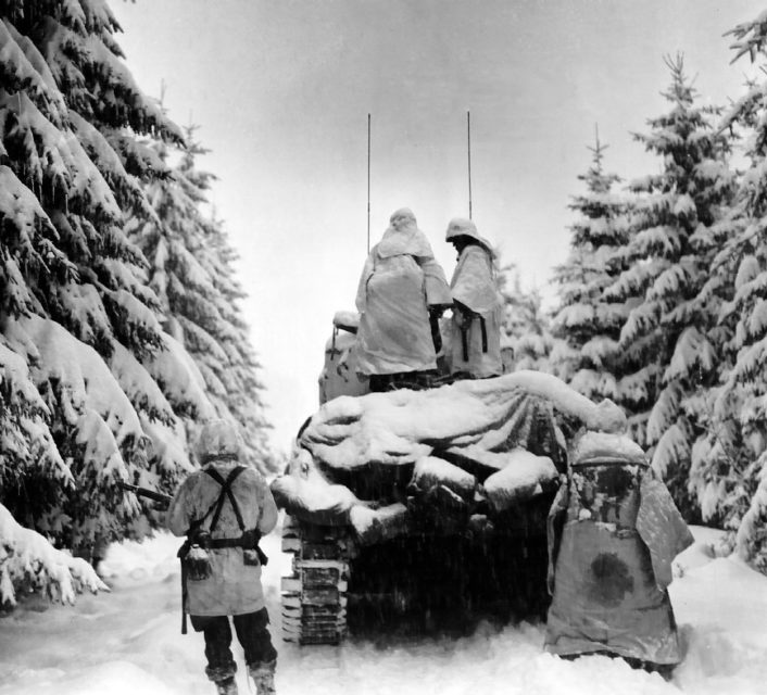 Tanks and Infantrymen of the 82nd Airborne Division, 740th Tank Battalion push through the snow towards their objective in Belgium. U.S. First Army near Herresbach.