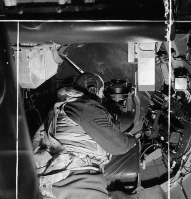 The bomb aimer in an Avro Lancaster, checking over the instruments in his position before take off from Scampton, Lincolnshire.