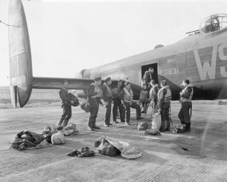 The crew of Avro Lancaster B Mark III boarding their aircraft at Bardney, Lincolnshire, for a raid on the Zeppelin works at Friedrichshafen, on the shores of Lake Constance, Germany.