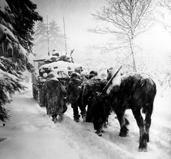 Troops of the 82nd Airborne Division advance in a snowstorm behind the tank in a move to attack Herresbach, Belgium. January 28 1945