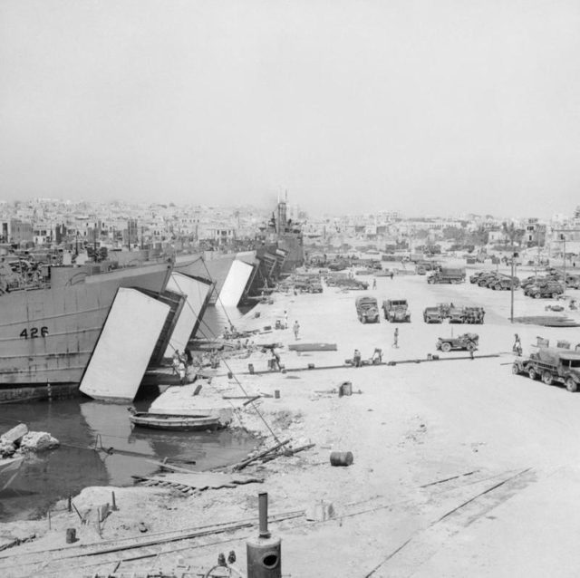 View of the dockside of Sousse Harbour, Tunisia. Landing craft are loaded with vehicles and equipped in preparation for the invasion. [© IWM (NA 3938)]