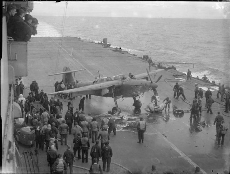 A Fairey Barracuda of 827 Squadron, Fleet Air Arm on fire from enemy flak having just landed on board HMS FURIOUS. The fire is put out by the crash party.