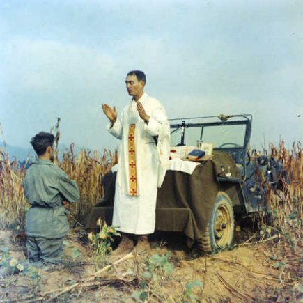 Father Emil Kapaun celebrating Mass using the hood of a jeep as his altar, October 7, 1950