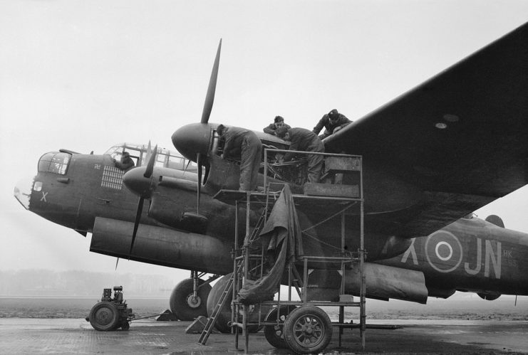 Mechanics working on the port-outer Merlin engine of a No 75 (New Zealand) Squadron Lancaster at Mepal, Cambridgeshire, 9 February 1945.