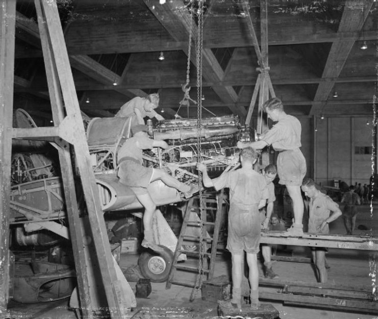 RAF fitters installing an overhauled and tested Rolls Royce Merlin engine in a Hawker Hurricane at No. 144 Maintenance Unit, Maison Blanche, Algeria.