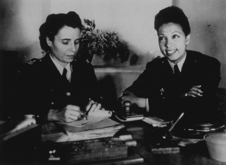 Josephine Baker sitting at a desk with another member of the Free French Women's Air Auxiliary