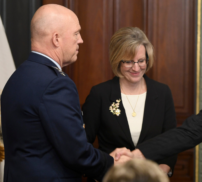 Mollie smiles next to Gen. John Raymond as the vice president congratulates him on his swearing-in.