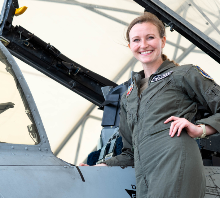 Taylor Bye standing next to the cockpit of her Republic Fairchild A-10C Thunderbolt II