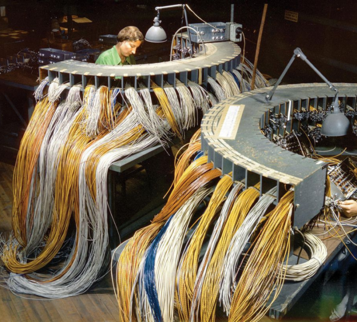 Two workers at a Consolidated-Vultee plant in Downey, California wire components for PB2Y flying boats.
