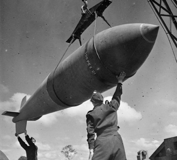 A 'Tallboy' is hoisted from the bomb dump to its carrier at Woodhall Spa, Lincolnshire, to be loaded into an Avro Lancaster.
