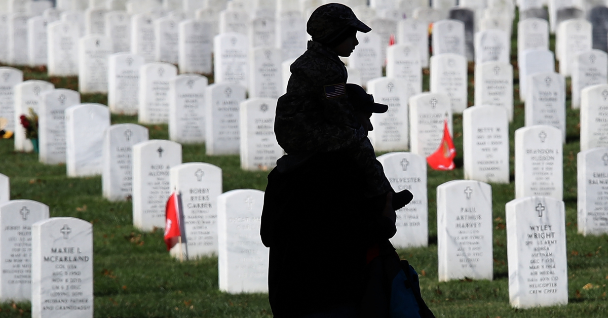A young boy rides on his father's shoulders while visiting Arlington National Cemetery on Veterans Day, 2017.