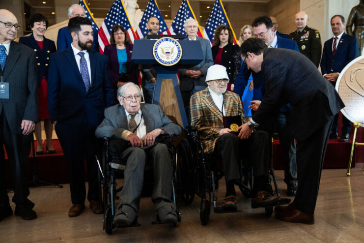 Speaker of the House Mike Johnson handing the Congressional Gold Medal to Bernard Bluestein as others look on