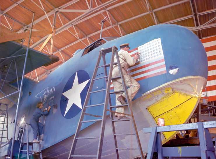 Two workers painting the exterior of a Martin PBM-3R