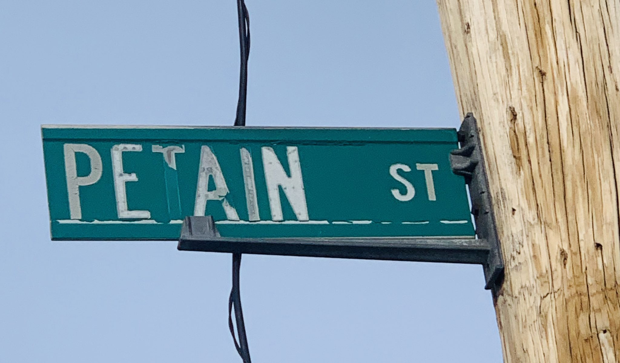 A worn street sign for Pétain Street in Pinardville, New Hampshire. (Photo Credit: TBlaze03103 / Wikimedia Commons CC BY-SA 4.0)