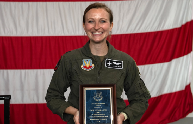 Taylor Bye holding her Air Combat Command Airmanship Award