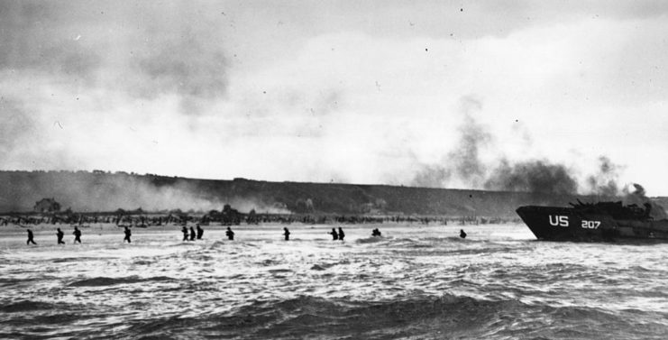 American infantrymen wading through water after disembarking from a landing craft