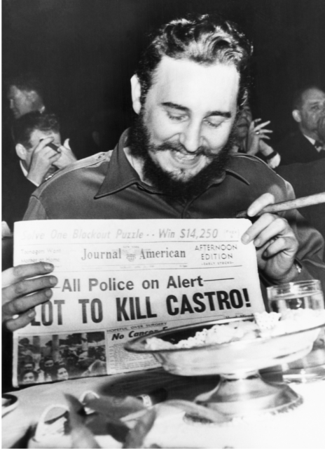 Fidel Castro laughing at a newspaper 