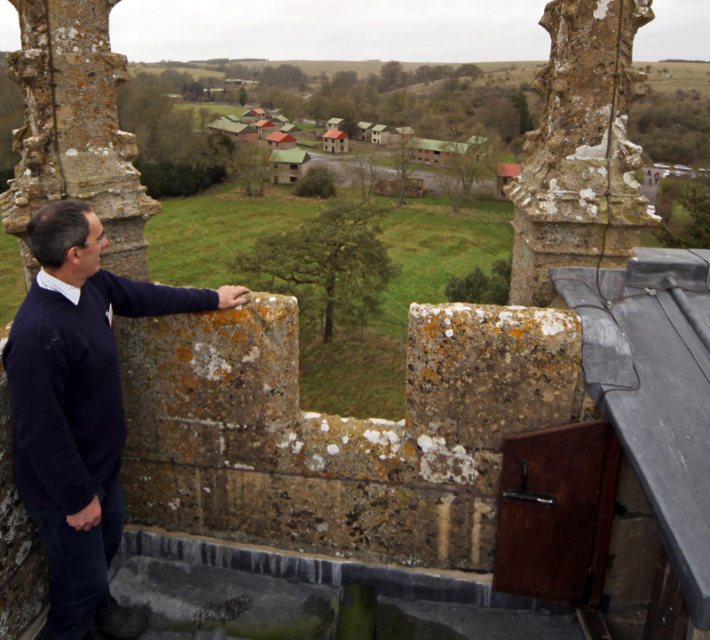 Church custodian Neil Skelton looks at the view from the church tower as the 10th New Year's Eve peace vigil is held inside the 700-year-old St Giles church in the village of Imber on December 31, 2011 on Salisbury Plain, England.