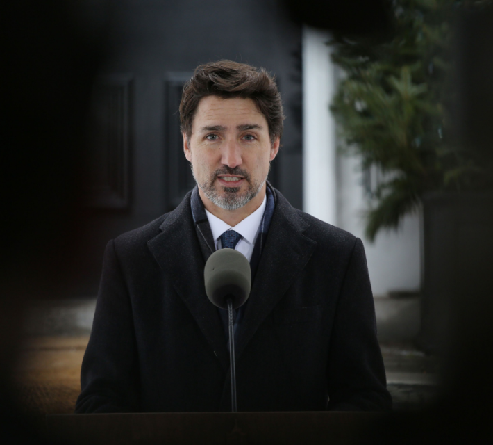 Canadian Prime Minister Justin Trudeau in front of a microphone.