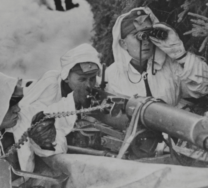 A Finnish machine-gun crew, wearing white to blend with the background of snow, in action against Russian troops.
