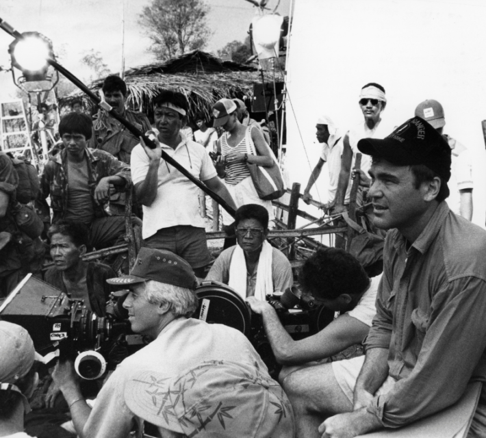 Oliver Stone sitting behind the camera during the filming of 'Platoon'