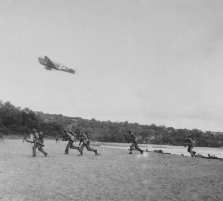 An Army P-40 gives close air support on the beach to United States troops and soldiers attacking Japanese forces at Rendova Island, of the Solomon Islands in the South Pacific, during World War II, 1943.