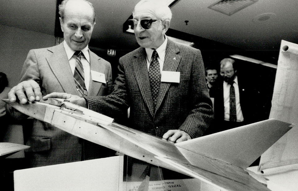 Test pilots lovingly examine a model of the scuttled Avro Arrow