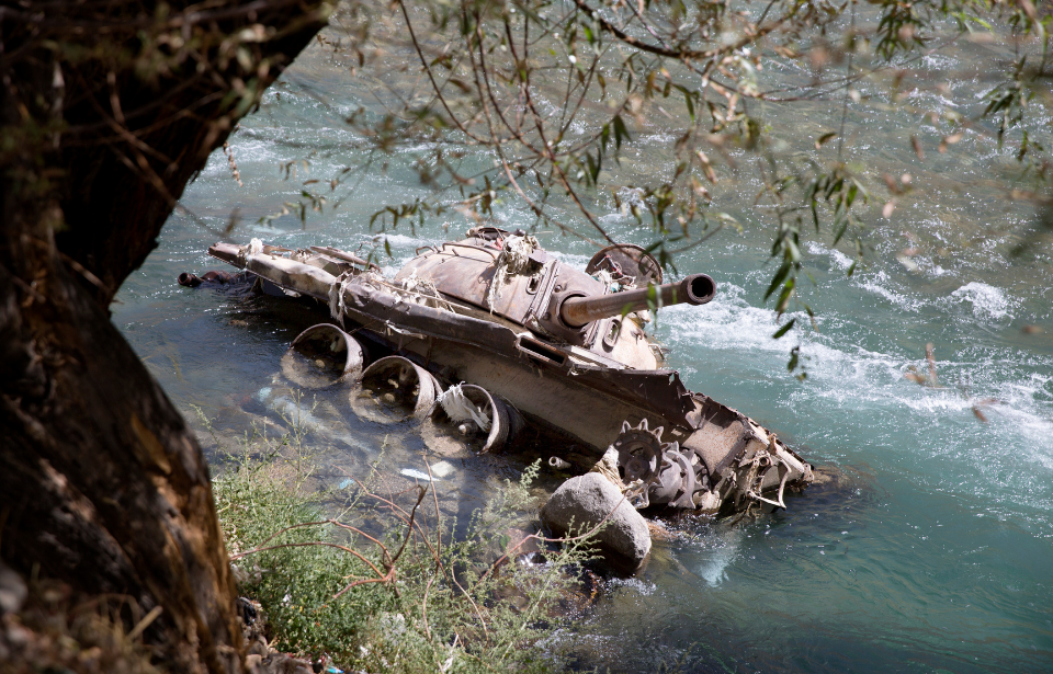A destroyed Soviet-era tank lies in the Panjshir River on September 5, 2016 in Bazarak, Afghanistan.