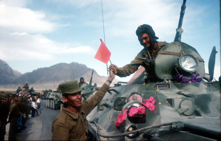A Soviet soldier is handed a flag as Soviet troops withdraw May 15, 1988 from Kabul, Afghanistan