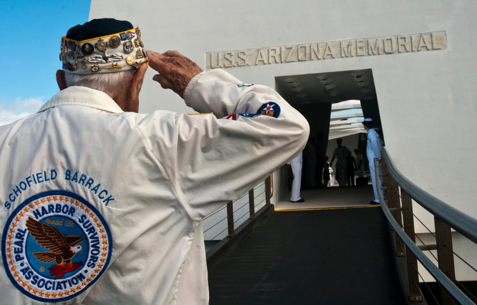 Army Sgt. (ret.) Allen Bodenlos, a Pearl Harbor survivor, salutes the Arizona memorial during a wreath laying ceremony at Joint Base Pearl Harbor-Hickam.